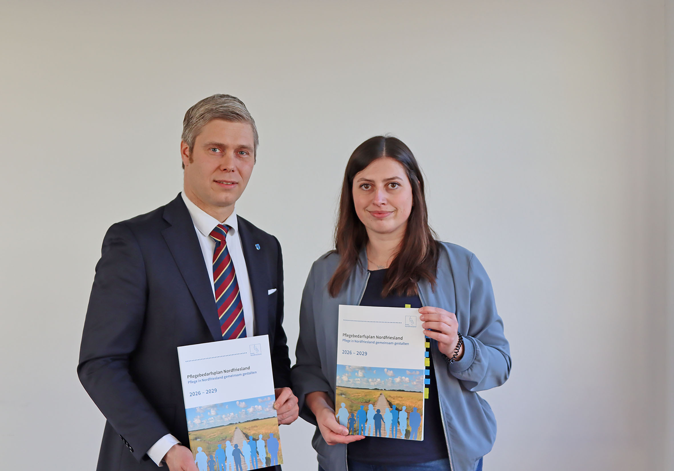 Landrat Florian Lorenzen und Saskia Voigt aus dem Fachbereich Soziales, Arbeit und Teilhabe präsentieren den Pflegebedarfsplan 2026 bis 2029. © Kreis Nordfriesland