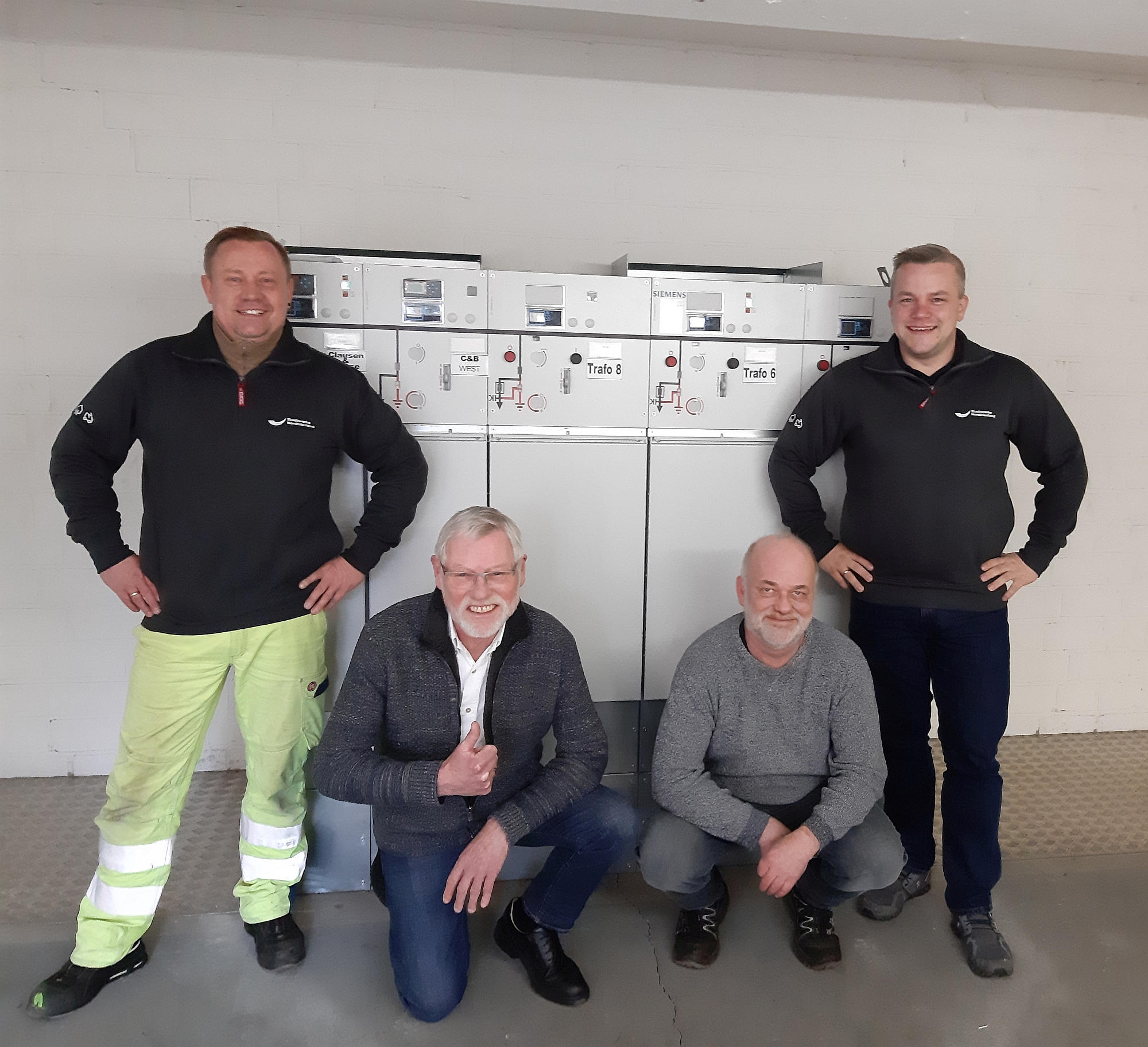 Das Foto zeigt vlnr Andreas Ulze (Elektriker SW NF), Rainer Ketelsen (Leitung Betriebstechnik C&B), Ralf Carstensen (Leiter E-Technik C&B) und Hauke Witte (Stellv. Leiter Technik Strom SW NF) vor der neuen Schaltanlage.